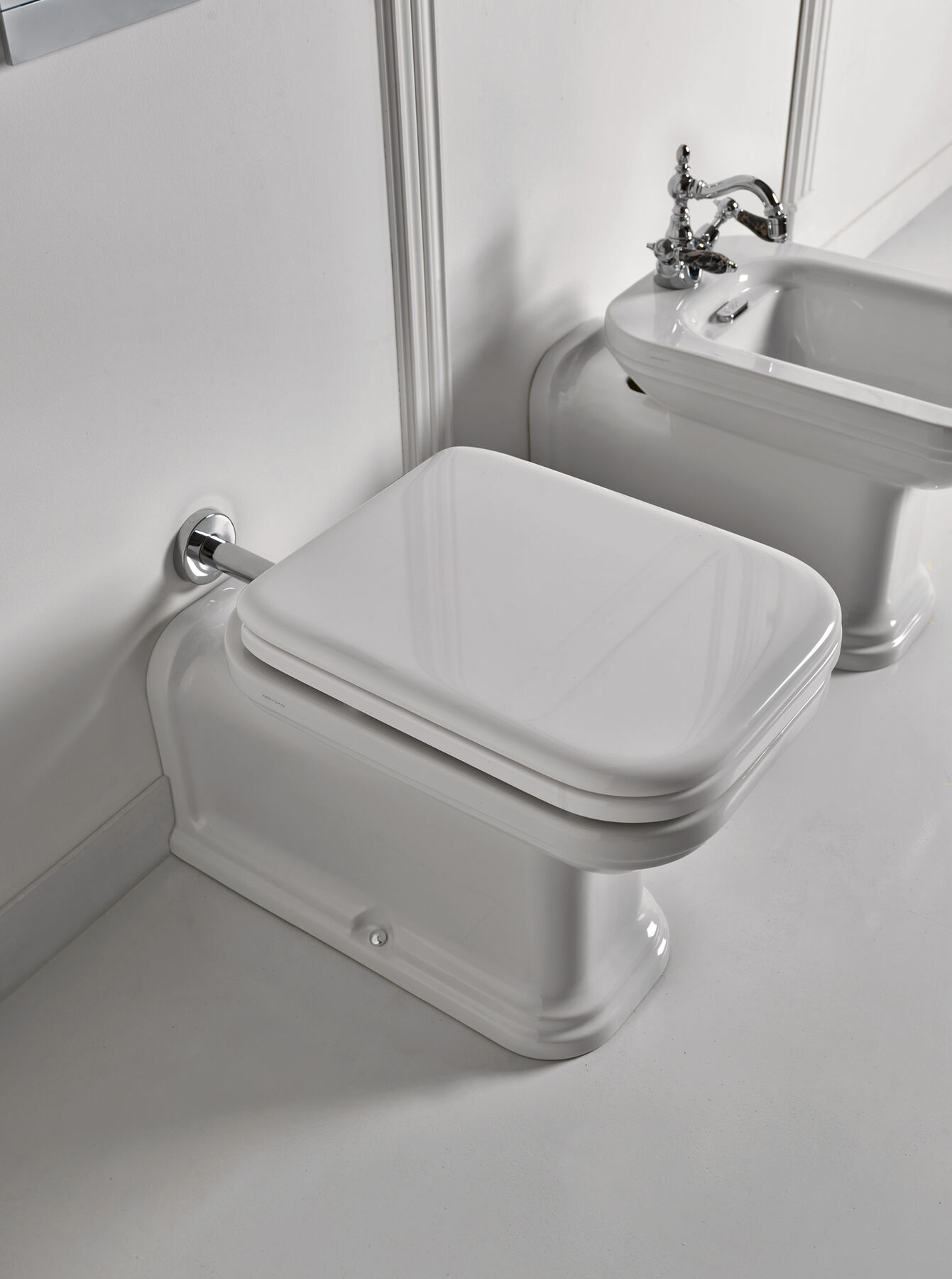 A period bathroom with a high-level cistern and a basin on a pedestal